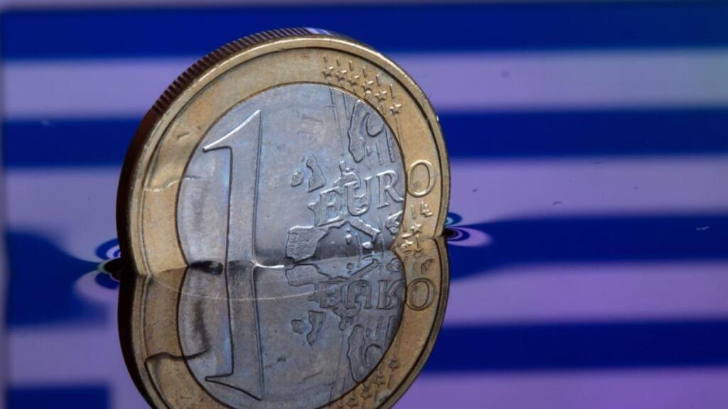 An illustration picture shows a one euro coin in water, which reflects the Greek flag, in Schwerin, Germany. Photograph: Jens Buettner/EPA