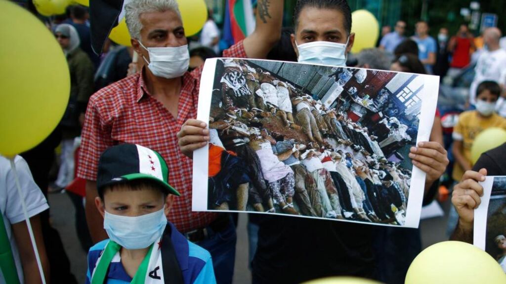 Protesters hold up images during a demonstration in front of the Syrian embassy in Sofia, Bulgaria, yesterday. Syrians living in Bulgaria had gathered  to protest against a suspected chemical weapons attack in Damascus. Photograph: Stoyan Nenov/Reuters