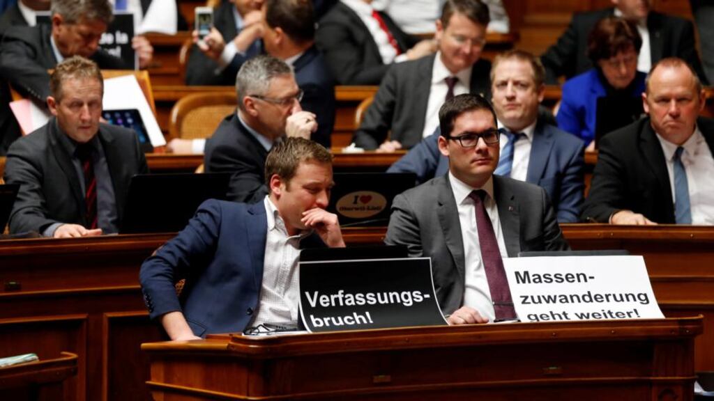 SVP members display posters reading ‘constitutional breach’ and ‘mass immigration continues’ after the vote in Bern. Photograph: Ruben Sprich/Reuters
