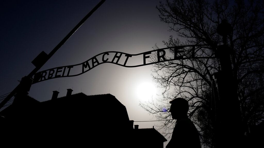 A man stands in front of the “Arbeit macht frei” (Work sets you free) gate in the former Nazi death camp Auschwitz, Poland. Photograph: Kacper Pempel/Reuters