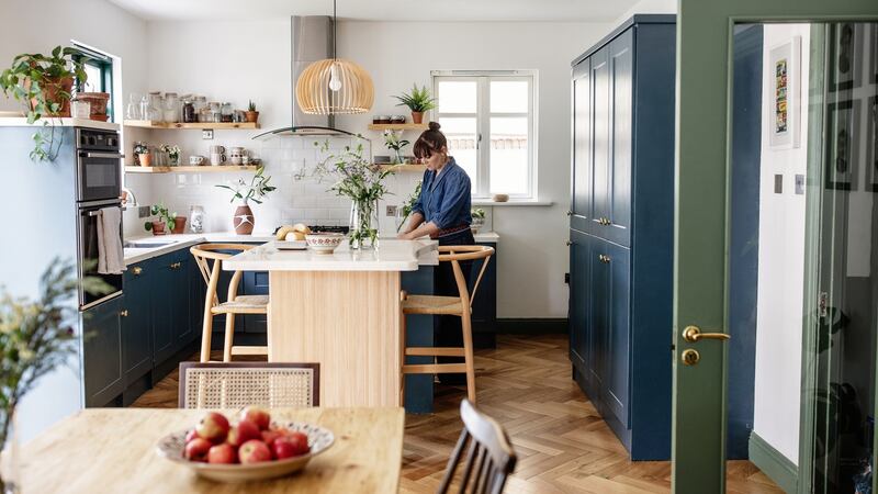 The couple made over their kitchen by painting the cabinetry, removing wall mounted cupboards to create open shelving, and revamped the laminate worktops to look like poured resin