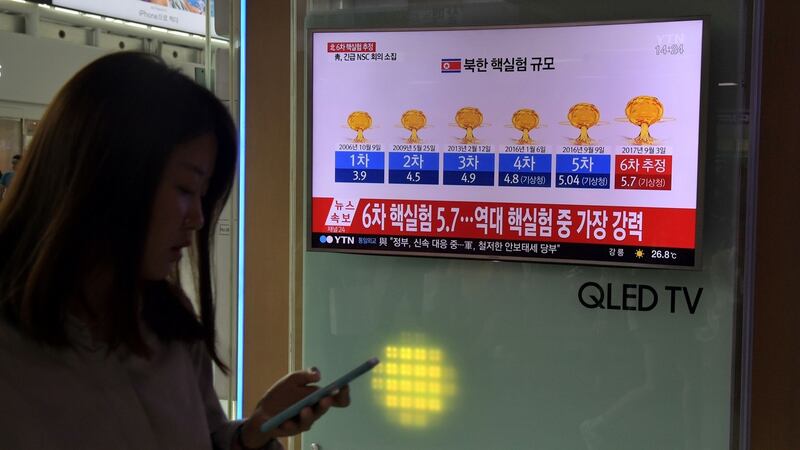 A woman walks past a television display at a train station in Seoul showing a news broadcast with a graphic about a history of North Korean nuclear tests. Photograph: AFP