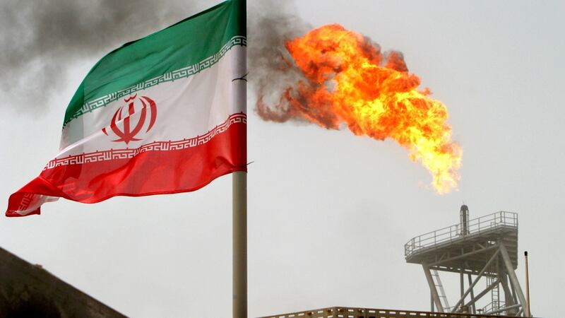 A gas flare on an oil production platform in the Soroush oil fields alongside an Iranian flag in the Persian Gulf, Iran. File photograph: Raheb Homavandi/Reuters