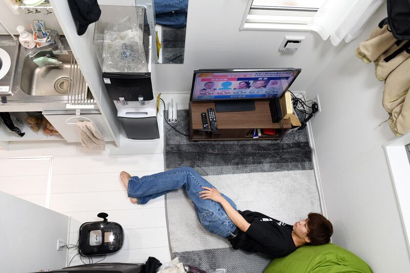 Yugo Kinoshita watches television in his apartment. Photograph: Noriko Hayashi/The New York Times