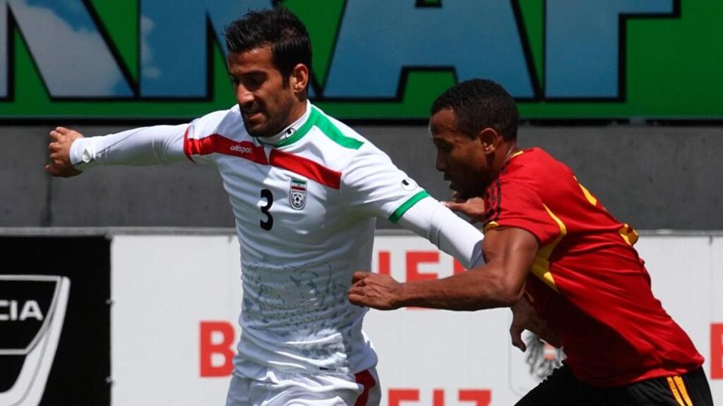 Iran’s Ehsan Hajsafi (left) challenges Angola’s Lunguinha during a friendly in Hartberg, Austria. Photograph: Heinz-Peter Bader / Reuters