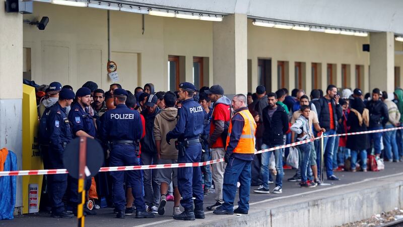 Austrian police watch as migrants wait for trains towards Germany from the Wien Westbahnhof railway station in Vienna. Photograph: Reuters