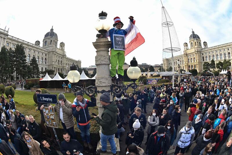 A demonstrator stands on a lamp post during a rally held by Austria’s far-right Freedom Party against the measures taken to curb the Covid-19 pandemic, at Maria Theresien Platz square in Vienna, Austria on Saturday. Photograph: Joe Klamar/AFP via Getty