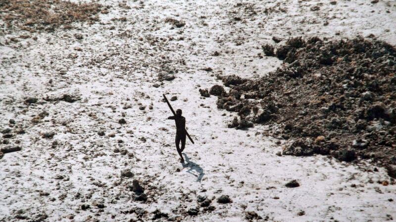 A man with the Sentinelese tribe aims his bow and arrow at an Indian coast guard helicopter as it flies over North Sentinel Island in the Andaman Islands after the 2004 Indian Ocean tsunami. Photograph: AFP/Getty Images