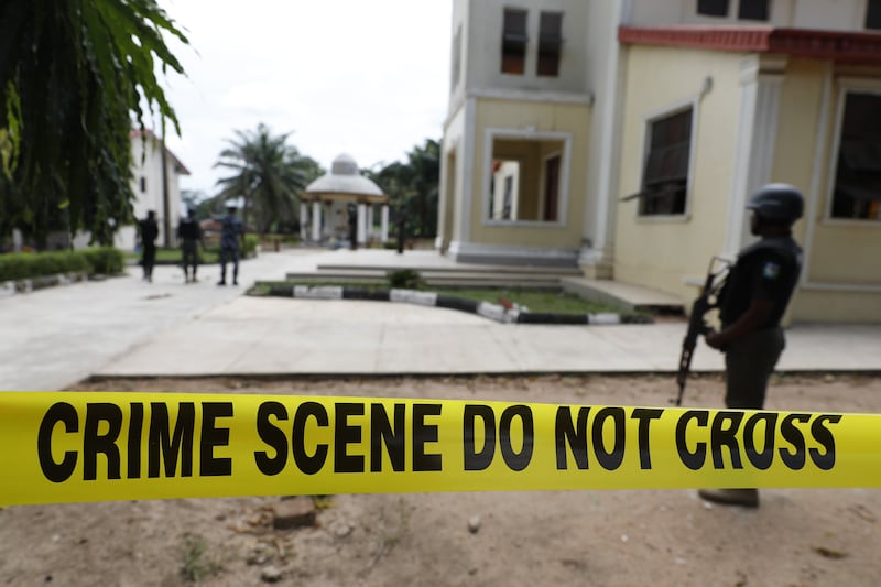 A policeman stands guard in front of St Francis Catholic Church the day after an attack by gunmen on worshippers.