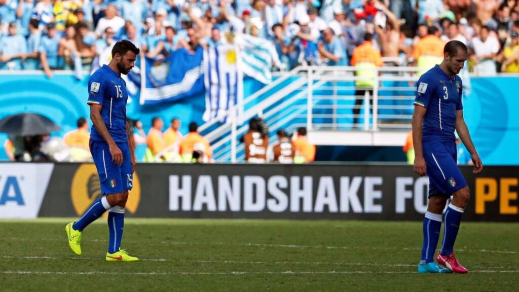 Andrea Barzagli and Giorgio Chiellini leave the pitch after losing to Uruguay in Natal. Photograph: EPA/