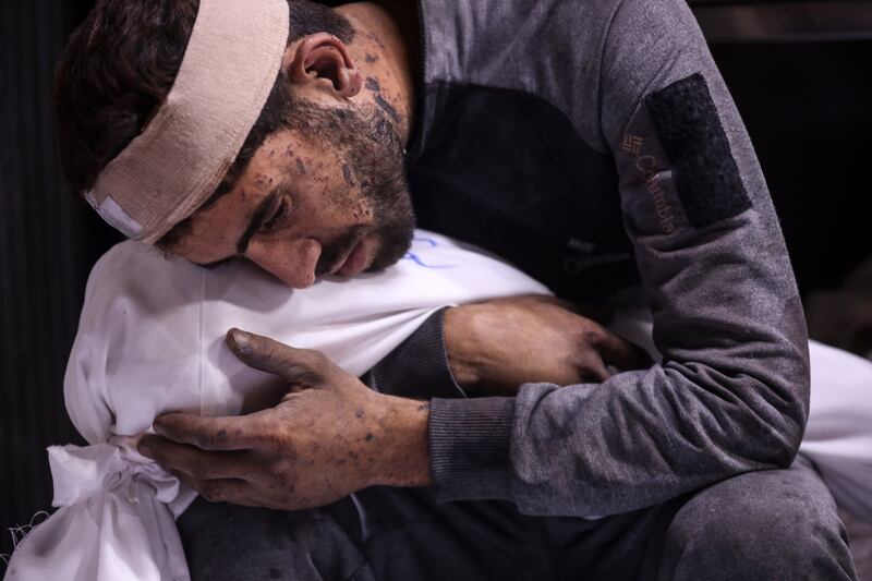 A man carries the body of a child, killed in an Israeli strike, ahead of a funeral procession in Gaza City. Photograph: Majdi Fathi/NurPhoto via Getty Images
