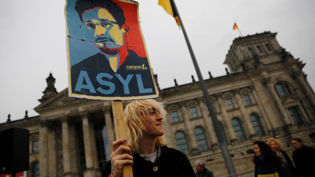 A protester holds a placard calling for Germany to give political asylum to the fugitive Edward Snowden, outside the Bundestag. Photograph: Reuters/Thomas Peter