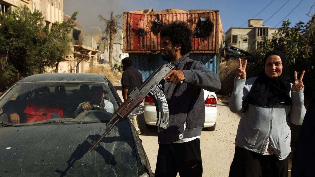 A woman flashes the sign for victory next to a fighter loyal to Libya’s eastern government in Benghazi after it seized the centre of the eastern coastal city on Tuesday following gains against Islamist militias including the Islamic State terrorist group. Photograph: Abdullah Doma/AFP/Getty Images