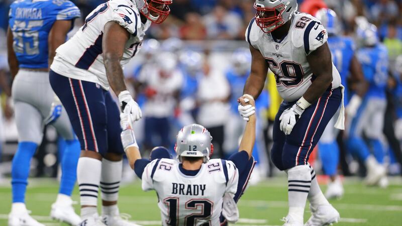 Trent Brown (L) and Shaq Mason help their quarterback Tom Brady after he was sacked during the New England Patriots’ defeat to the Detroit Lions. Photograph: Rey Del Rio/Getty