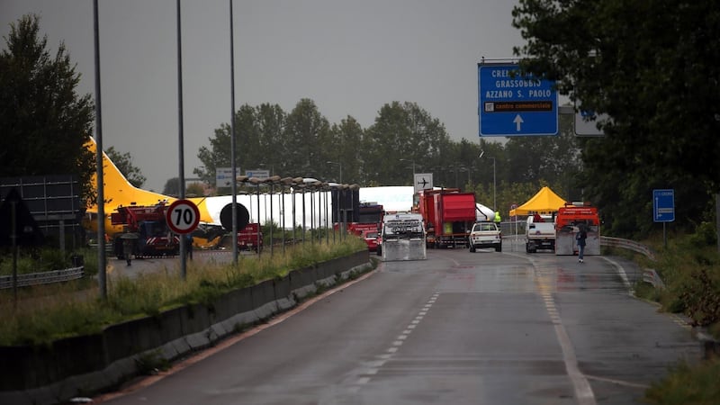 Firefighters work on DHL cargo plane that skidded off a runway at Orio al Serio airport overnight, busting through a perimeter fence and onto a provincial highway, near Bergamo in Northern Italy, Friday, August 5th, 2016. Photograph: Matteo Bazzi/ANSA via AP Photo