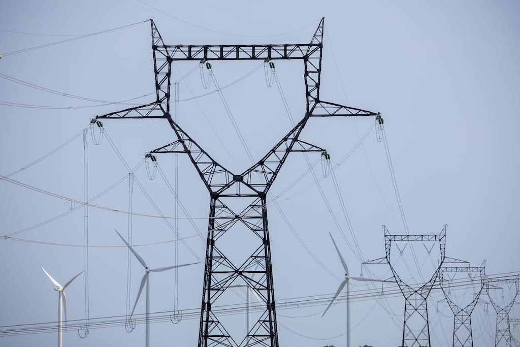 A wind farm and high-voltage power line pylons linked to the Nogent-sur-Seine nuclear power plant, operated by the French energy company EDF. Construction of an electricity interconnector to France is under way