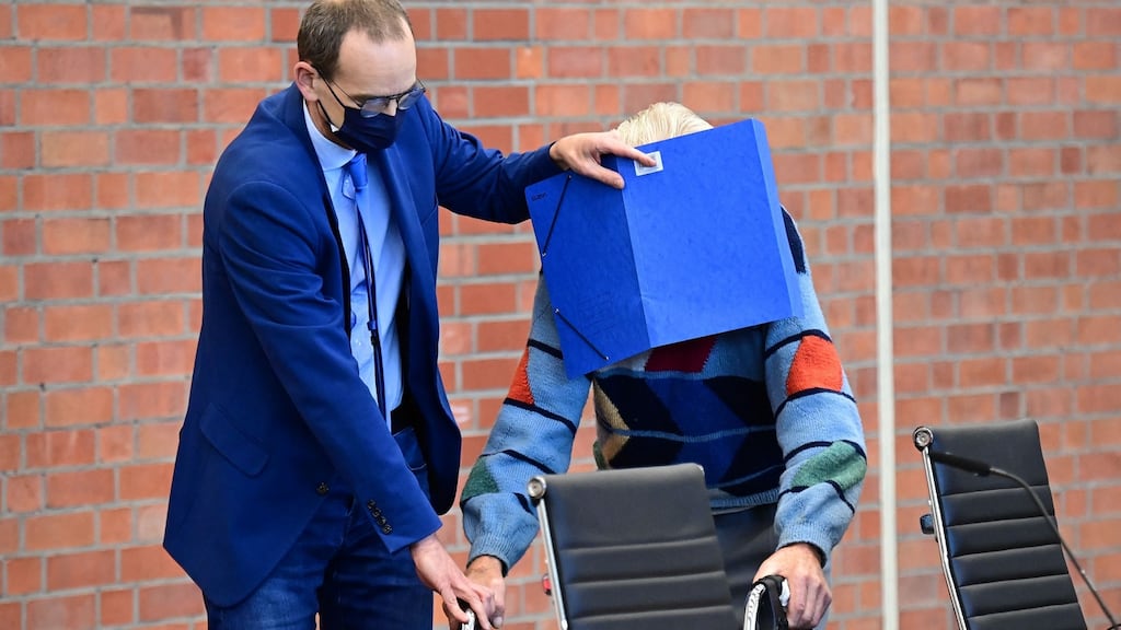 Defendant Josef S gets help from his lawyer Stefan Waterkamp, left, to hide his face as he arrives for his trial in Brandenburg. Photograph: Tobias Schwarz / AFP