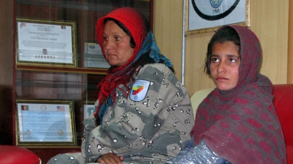 An Afghan security official sits next to an young alleged suicide bomber detained by the Afghan police officials in Helmand, Afghanistan. Photograph: Watan Yar/EPA