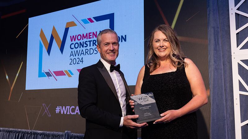 Gareth Lloyd, operations director-construction, Walls Construction, presents the best in health and safety leadership award to the Laura McCooey, Elliott Group