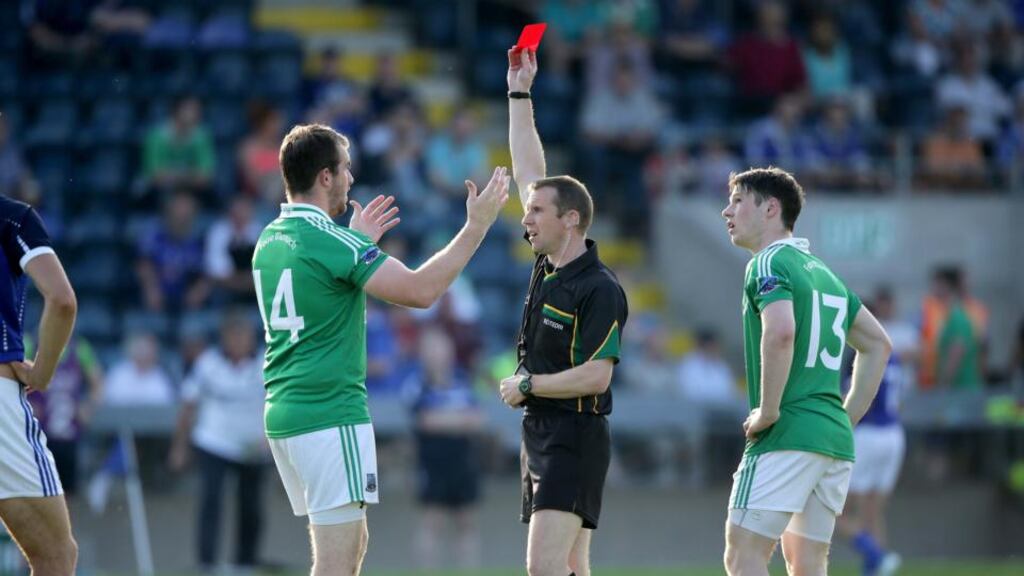 Michael Duffy shows a red card to Fermanagh’s Seán Quigley for an incident at the end of the first half during the All-Ireland football qualifier at Breffni Park. Photograph: Morgan Treacy/Inpho