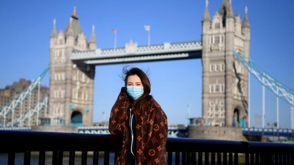 A woman wears a protective mask in front of Tower Bridge in London. There have now been 5,683 diagnosed cases in the UK and 281 deaths. Photograph: Alex Davidson/Getty