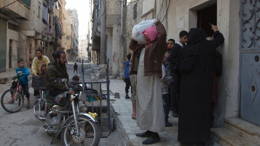 Syrian families receive aid packages from the  Al-Sham Humanitarian Foundation in the rebel-held neighbourhood of al-Marjah in Aleppo. Photograph: Karam Al-Masri/AFP/Getty Images