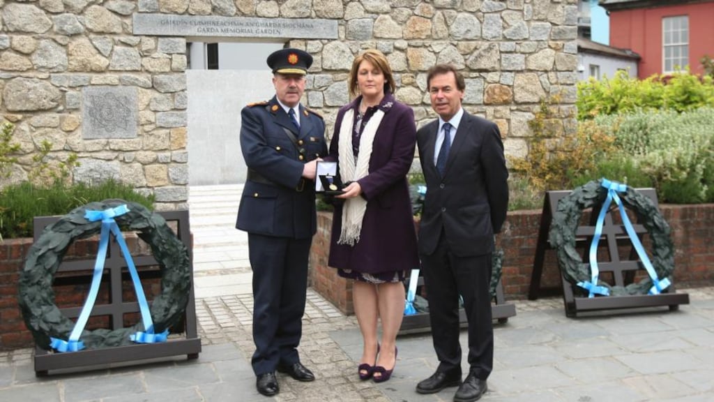 Garda Commissioner Martin Callinan and Minister for Justice Alan Shatter present a medal to Adrian Donohoe’s wife Caroline as they attend a memorial service for gardai killed in the line of duty at Dublin Castle. Photograph: Niall Carson/PA Wire