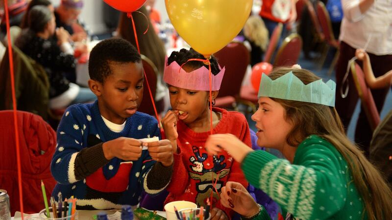 Volunteer Sarah Whelehan with brother and sister Toonna (left) and Diamond Brown, at the Knights of Columbanus Christmas dinner, in the RDS Dublin. Photograph: Dara Mac Dónaill /The Irish Times