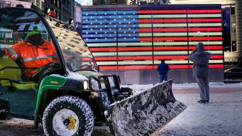 A worker spreads road salt and plows snow in a plaza in Times Square on Friday. Photograph: Drew Angerer/Getty Images