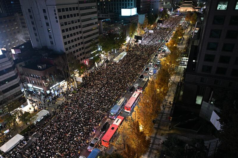 Thousands attend a candlelight vigil in Seoul. Photograph: Anthony Wallace/AFP via Getty Images