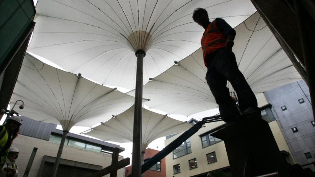 Fitting the Irish-designed large-scale umbrellas at Meeting House Square in Temple Bar, Dublin, in 2011, to create an all-weather cultural space. Photograph: Cyril Byrne/The Irish Times