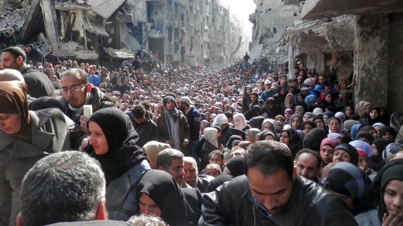 Residents queue for food in the Yarmouk refugee camp in January 2014. Photograph: Unrwa via Getty Images