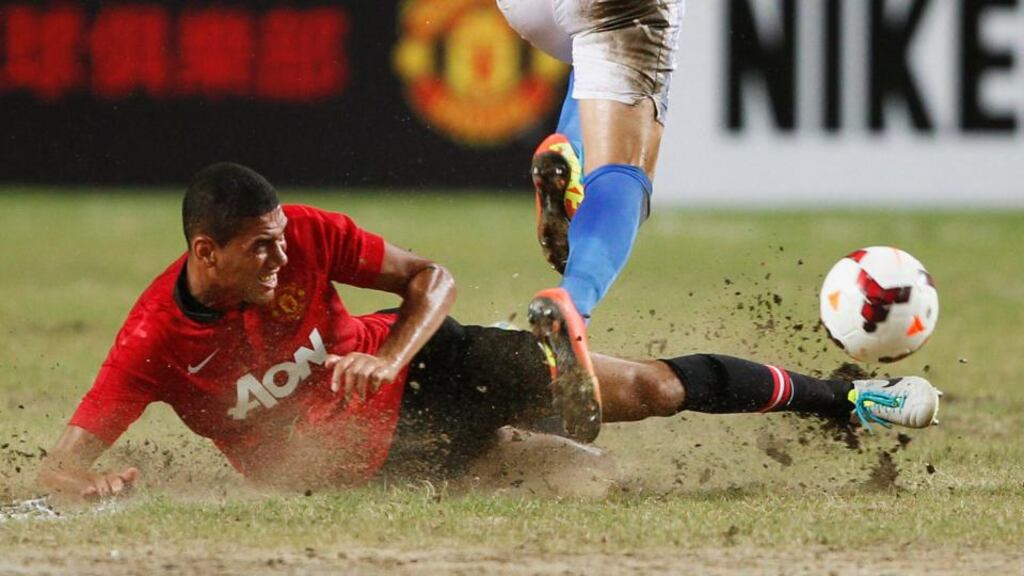Manchester United’s Chris Smalling tackles Kitchee’s Juan Carlos Rodriguez Belencoso on a partly sandy ground during their friendly match at the Hong Kong Stadium in Hong Kong. Photograph: Bobby Yip/Reuters