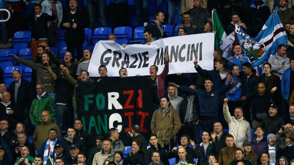 Manchester City supporters hold up banners in support of their former manager Roberto Mancini during the match against Reading at the Madejski Stadium. Photograph: Darren Staples/Reuters