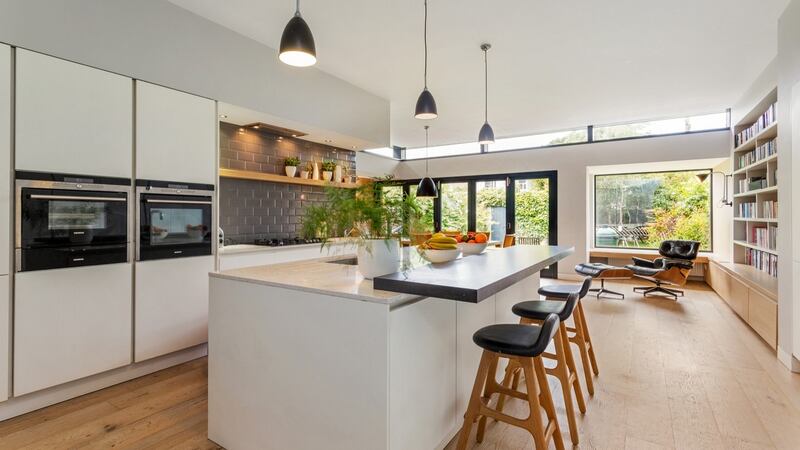 Kitchen laid out around a large island that has an integrated breakfast bar