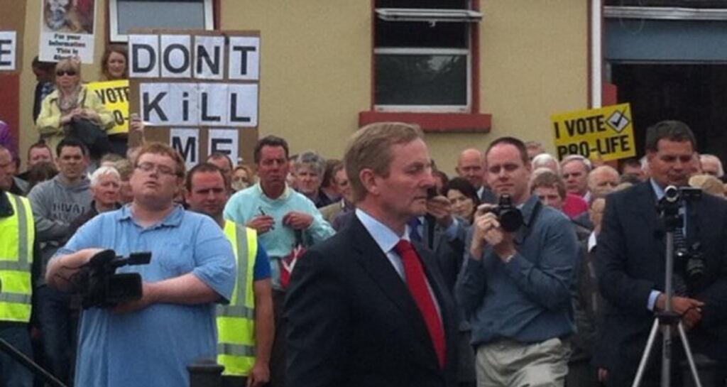 Taoiseach Enda Kenny walks past anti-abortion campaigners at the unveiling of a statue to General Sean MacEoin in Longford yesterday. Photograph: Ted Leddy via Twitter