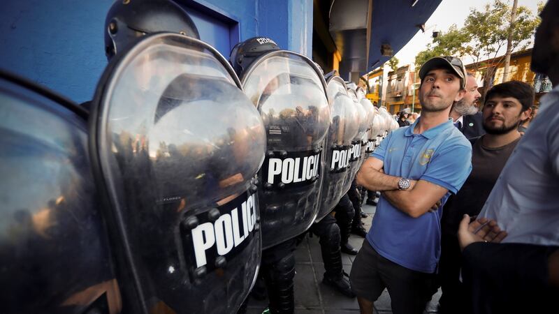 Policemen on guard as fans queue to buy tickets for the first match of the Copa Libertadores final. Photograph: Juan Ignacio Roncoroni/EPA