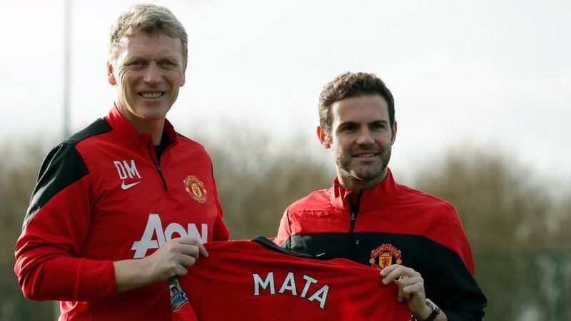 Manchester United’s new signing Juan Mata (right) holds a club shirt alongside manager David Moyes at the club’s Carrington training comple. Photograph: Phil Noble/Reuters