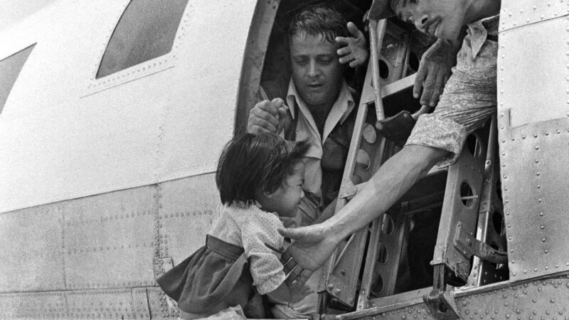 A child is pulled into an Air America plane headed for Saigon from Da Nang airport, March 27th, 1975. Photograph: Nguyen Ngoc Luong/The New York Times
