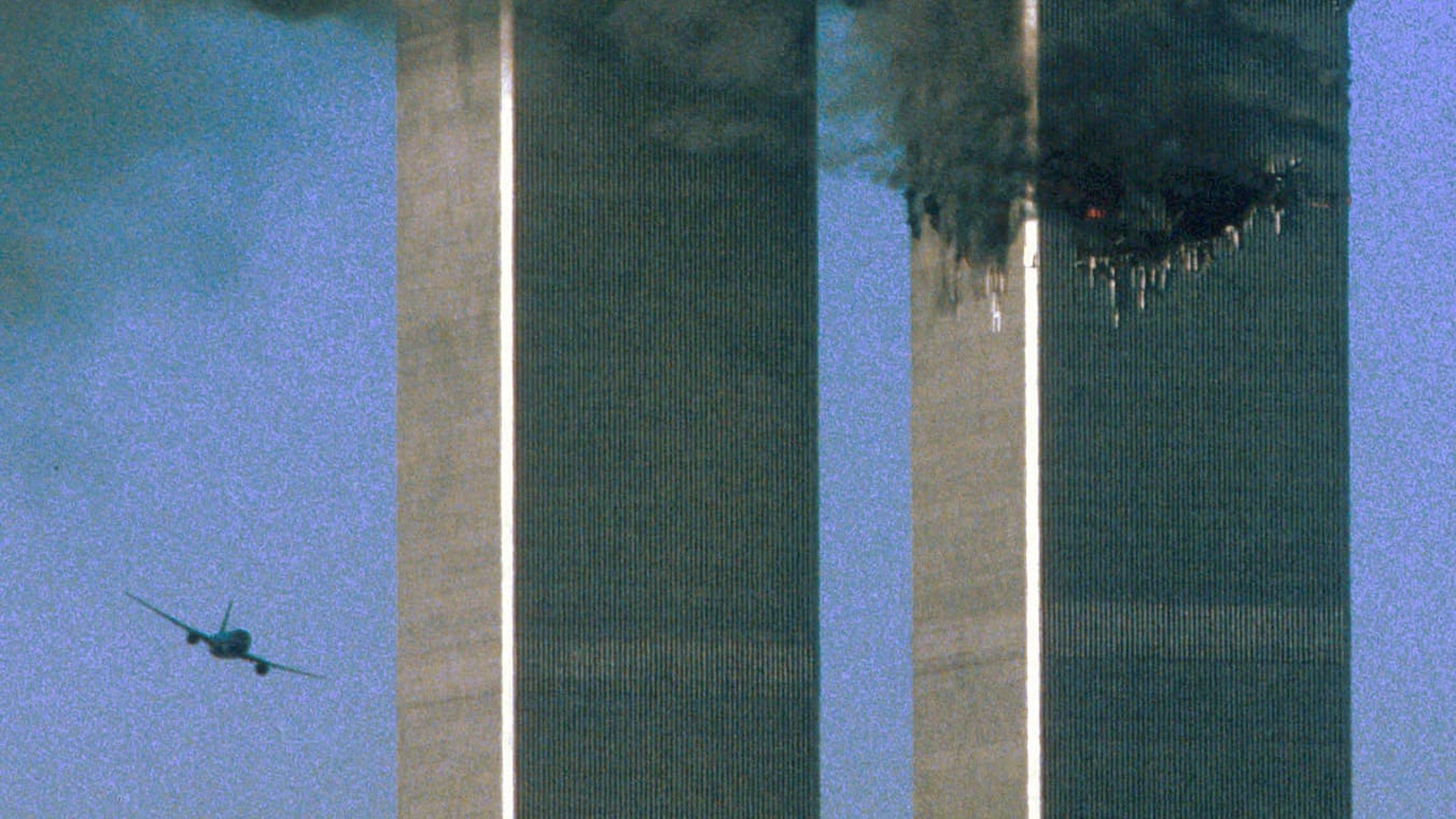 Hijacked United Airlines Flight 175 (left)  flies toward the World Trade Center twin towers shortly before hitting  the south tower (left) as the north tower burns following an earlier attack by a hijacked airliner in New York city on September 11th, 2001. Photograph: Reuters/Sean Adair