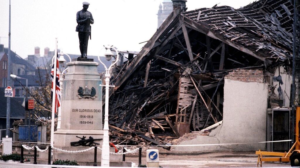 The Cenotaph at Enniskillen in 1987 with the devastated community centre in the background after it was hit by an IRA bomb.   Photograph: PA