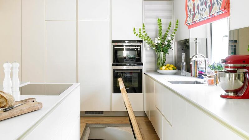 A basement hatch set into the kitchen floor provides room for a wine cellar.