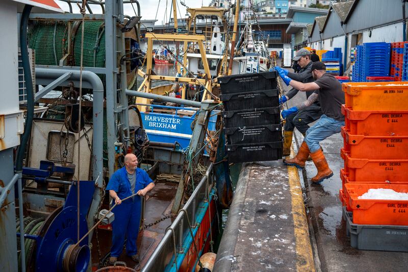 Crew members unload fish at the harbour in Brixham. Photograph: Andrew Testa/New York Times