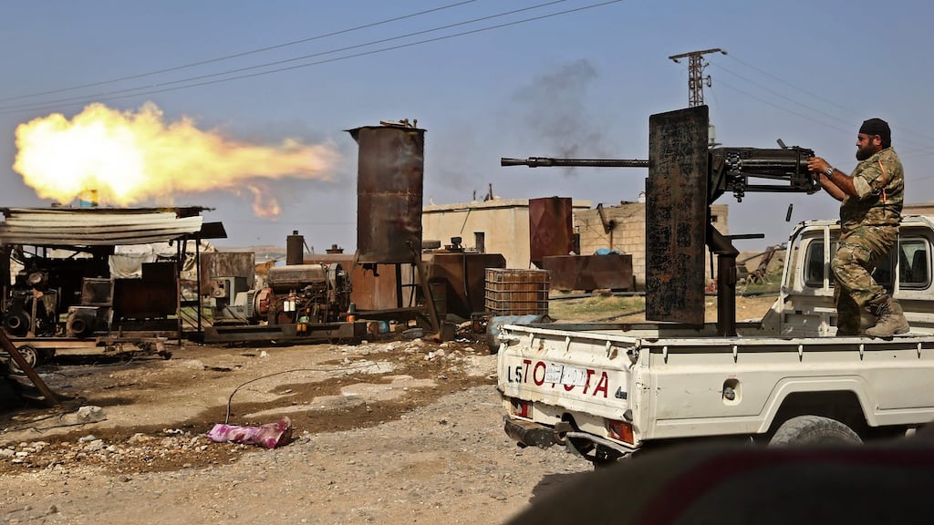 A Turkish-backed Syrian fighter fires during clashes in the border town of Ras al-Ain on Sunday. Photograph: Nazeer al-Khatib/AFP/Getty Images