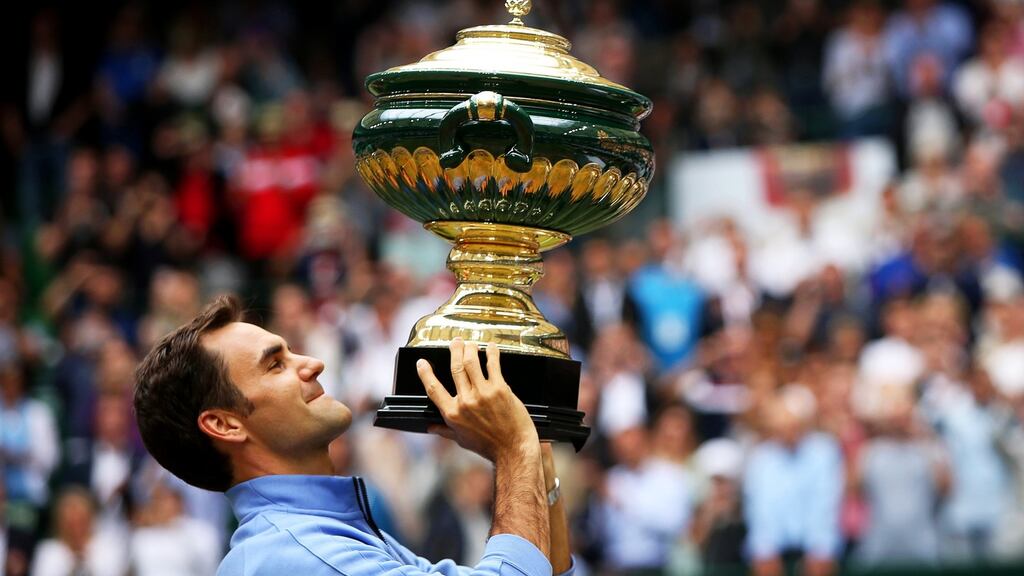 Roger Federer of Switzerland lifts his trophy after defeating Alexander Zverev of Germany to win at Halle. Photo: Tyler Larkin/EPA