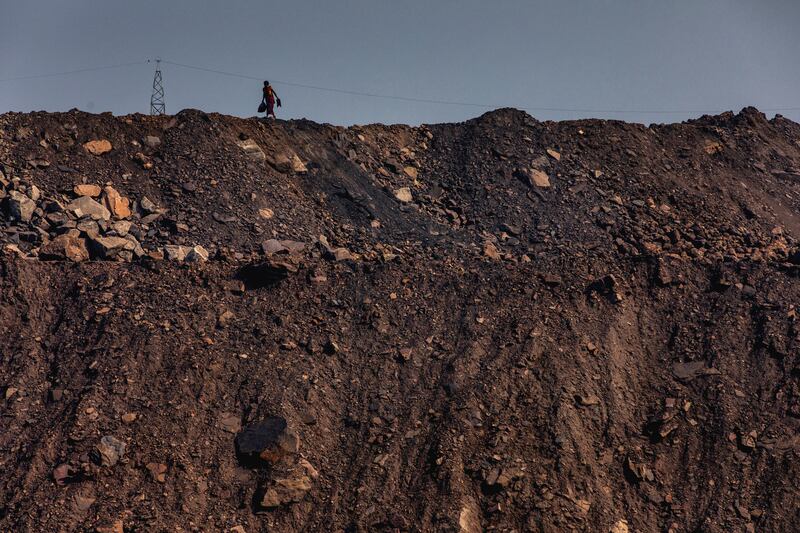 A woman walks on the edge of a coal mine at Jharia coalfield. Photograph: Jonas Gratzer/LightRocket/Getty Images