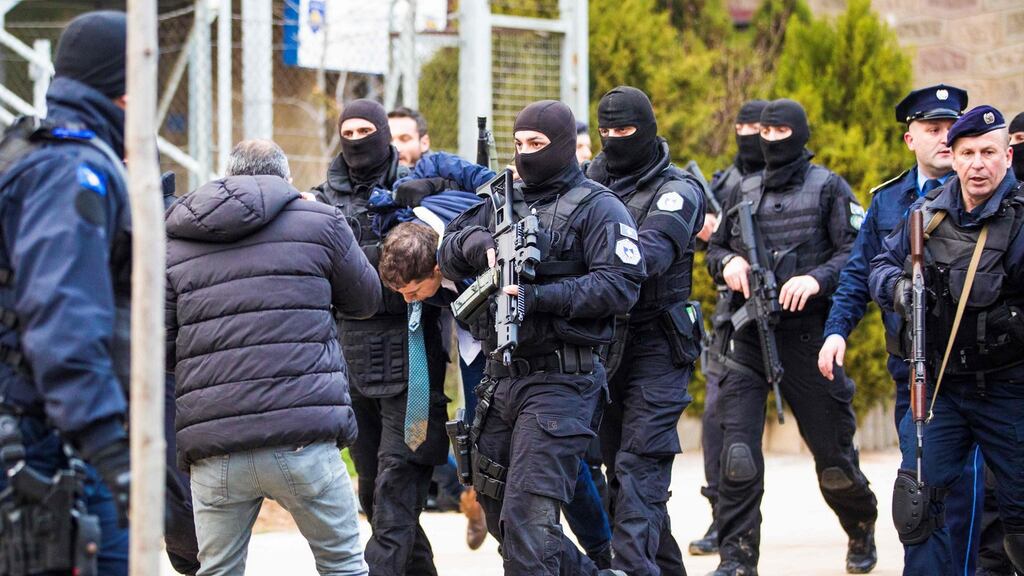 Kosovo police officers escort senior Serbian official Marko Djuric (centre) near the police station in Pristina. Photograph:  AFP