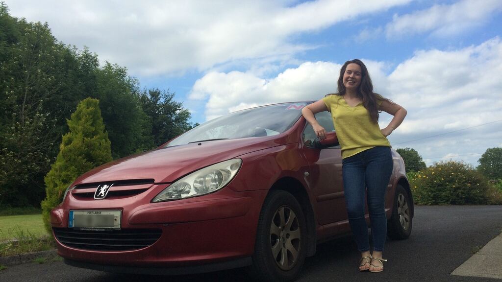 Niamh Towey with her car, which now has a back window and a fully complete exhaust system