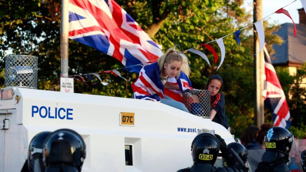 Loyalist protesters climb on an armoured police vehicle in the Woodvale Road area of north Belfast last Sunday. Photograph: Cathal McNaughton/Reuters