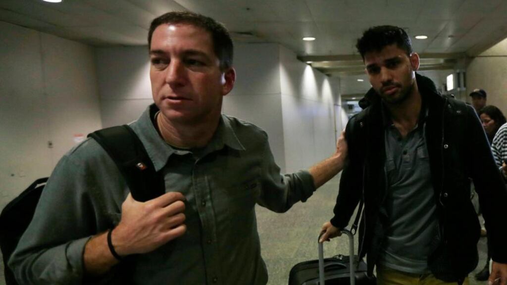 Journalist Glenn Greenwald (left) with his partner David Miranda in Rio de Janeiro’s international airport yesterday. Mr Miranda said he was questioned by six agents on his “entire life”. Photograph: Ricardo Moraes/Reuters